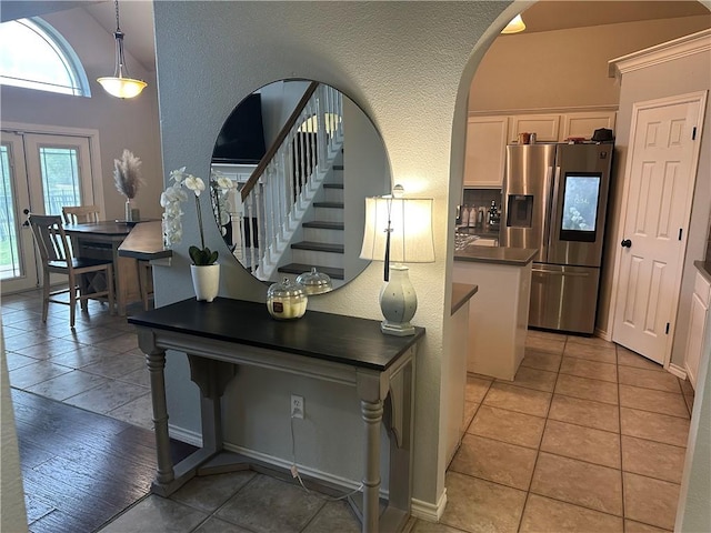 6333 Oso Pkwy, Corpus Christi, TX 78414 - staircase featuring arched walkways, a textured wall, lofted ceiling, and tile patterned floors