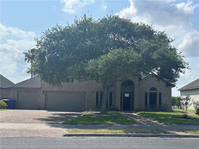 6333 Oso Pkwy, Corpus Christi, TX 78414 - view of property hidden behind natural elements with a garage, driveway, and brick siding