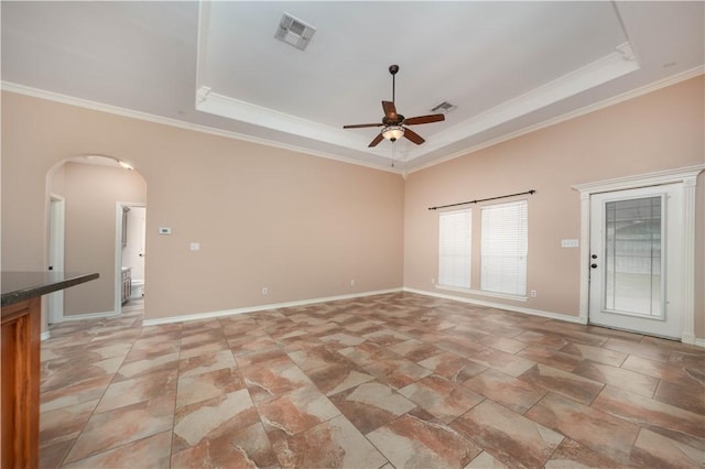 unfurnished room featuring arched walkways, ornamental molding, a raised ceiling, and visible vents