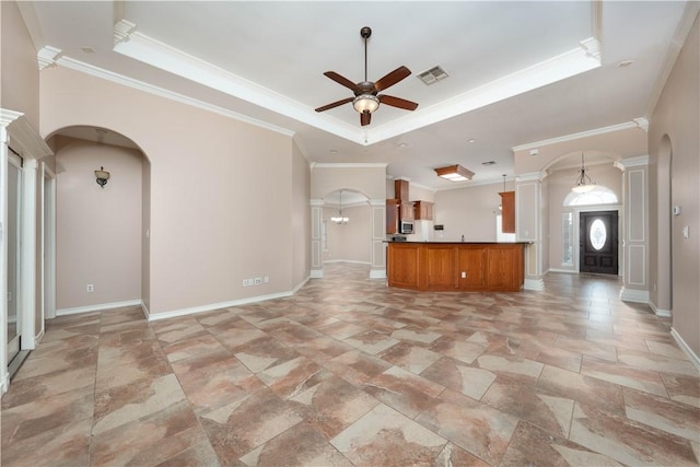 unfurnished living room featuring arched walkways, a raised ceiling, visible vents, and a ceiling fan