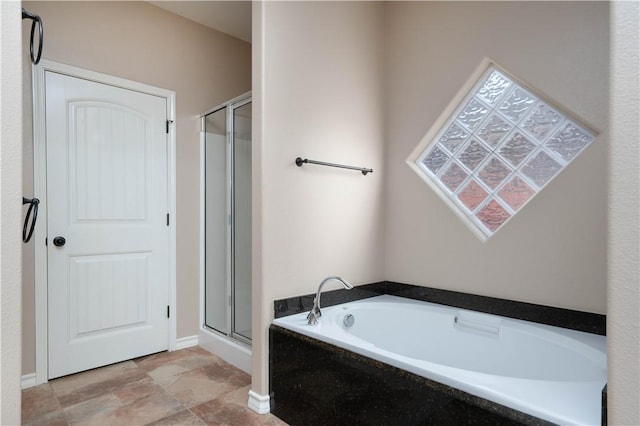 full bathroom featuring a garden tub and a shower stall