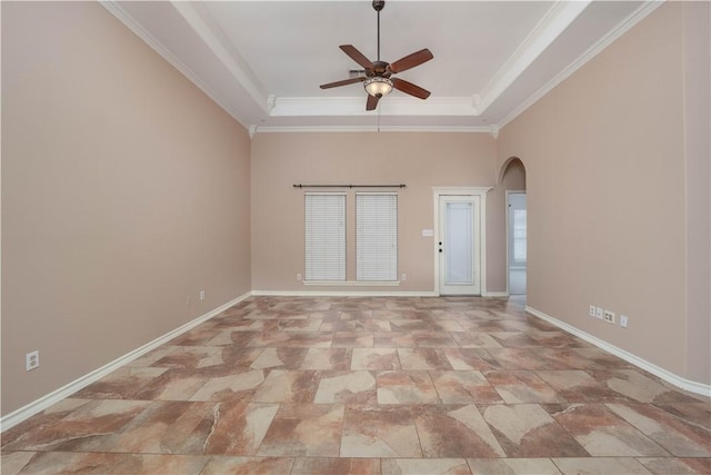 unfurnished room with ornamental molding, arched walkways, baseboards, and a tray ceiling