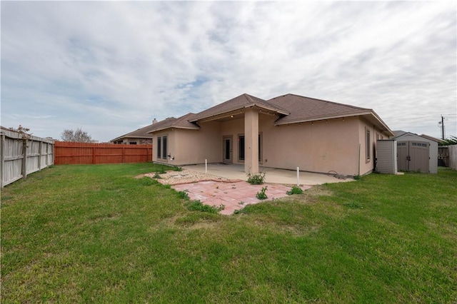 rear view of house with a patio, a fenced backyard, a storage shed, an outdoor structure, and stucco siding