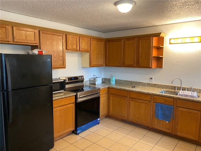 kitchen featuring a textured ceiling, black appliances, sink, and light tile patterned floors