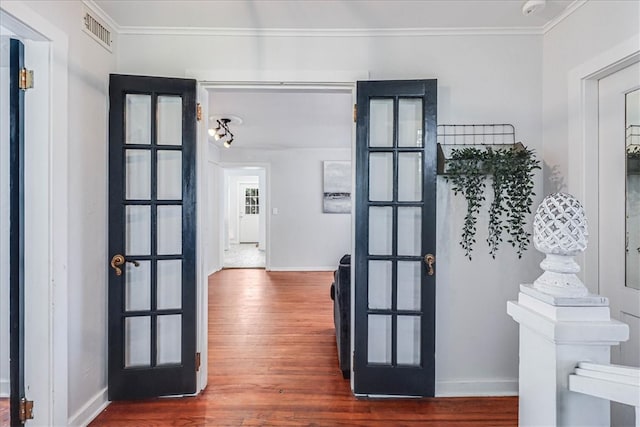 interior space with french doors, wood-type flooring, and crown molding