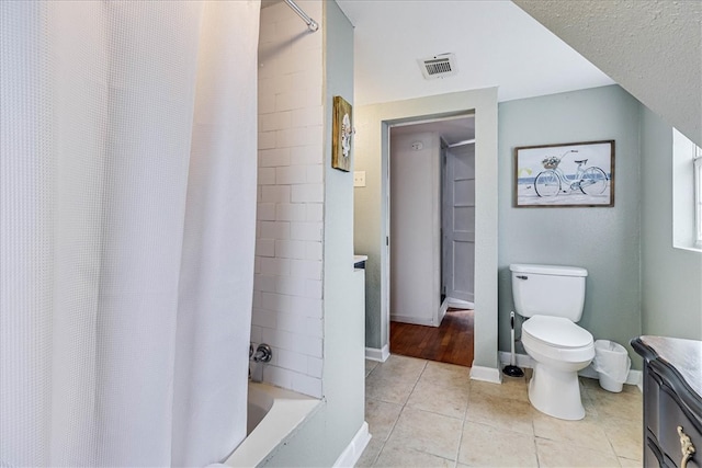 full bathroom featuring toilet, vanity, shower / bath combo with shower curtain, and tile patterned floors