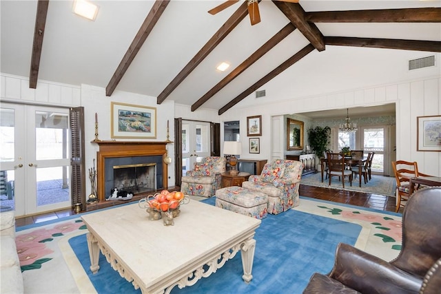 living area with french doors, visible vents, a fireplace, and beamed ceiling