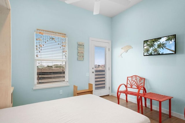 bedroom featuring a ceiling fan, access to outside, baseboards, and wood finished floors