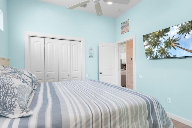 bedroom with visible vents, a ceiling fan, a closet, and wood finished floors