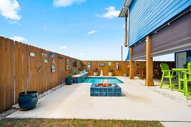 view of swimming pool featuring a fenced backyard, a fire pit, and a patio