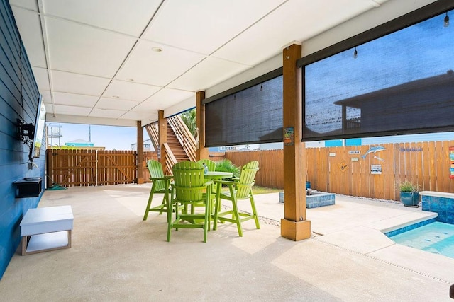 view of patio / terrace featuring stairs, outdoor dining space, and fence