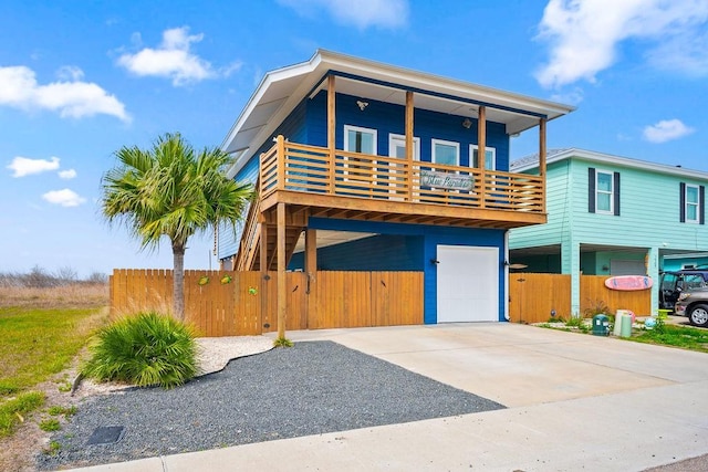 view of front of home featuring a garage, concrete driveway, and fence