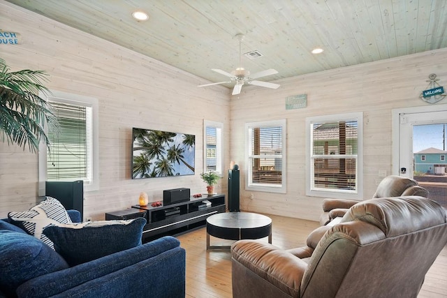 living area featuring wood ceiling, wooden walls, and light wood finished floors