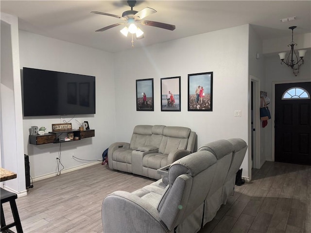 living room featuring hardwood / wood-style floors and ceiling fan with notable chandelier