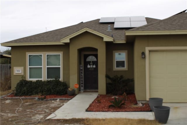 view of front of home with a garage and solar panels