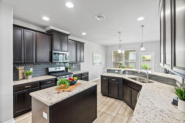 2530 Las Estrellas St, Corpus Christi, TX 78414 - kitchen featuring stainless steel appliances, tasteful backsplash, light stone countertops, recessed lighting, and pendant lighting