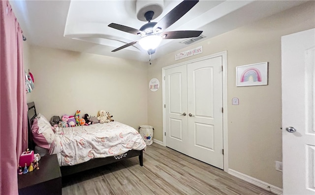 bedroom featuring light hardwood / wood-style flooring, ceiling fan, and a closet