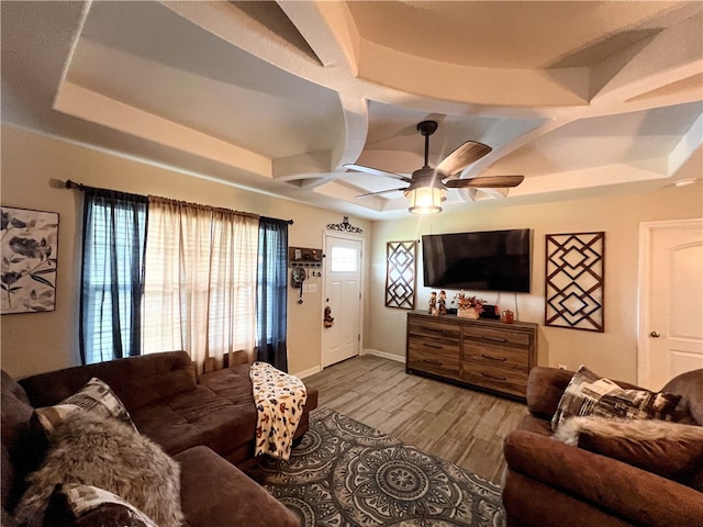 living room with light wood-type flooring, ceiling fan, and a tray ceiling