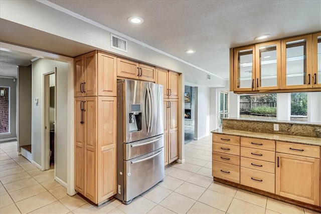 kitchen with light stone countertops, stainless steel fridge with ice dispenser, crown molding, and light tile patterned flooring