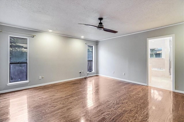 empty room featuring ceiling fan, crown molding, a textured ceiling, and hardwood / wood-style flooring