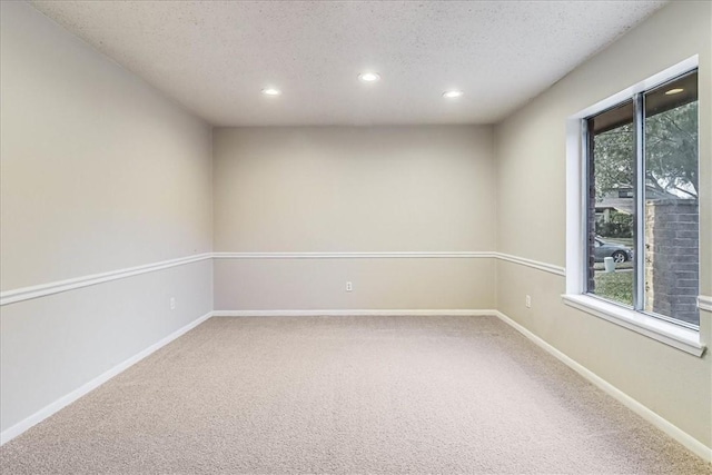 carpeted spare room with a textured ceiling