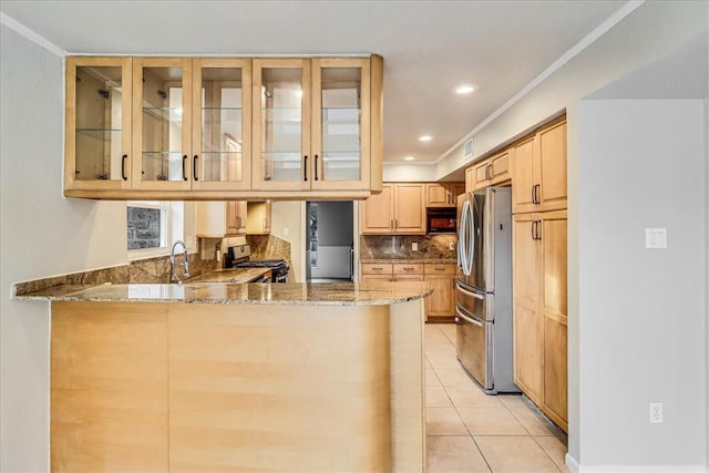 kitchen featuring light tile patterned floors, kitchen peninsula, appliances with stainless steel finishes, light brown cabinetry, and light stone counters