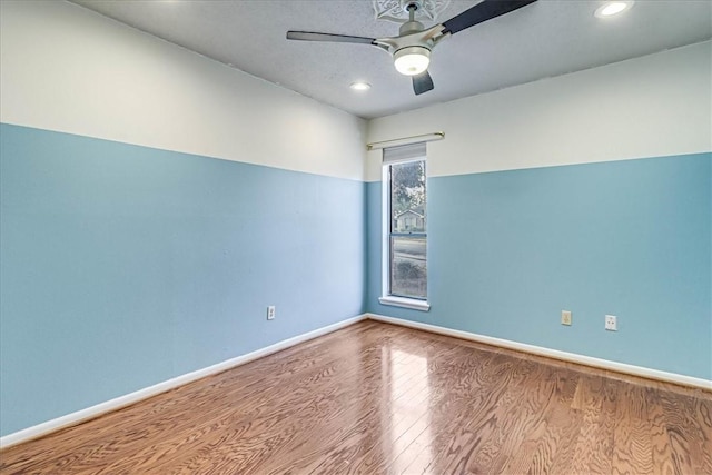 spare room with ceiling fan and wood-type flooring