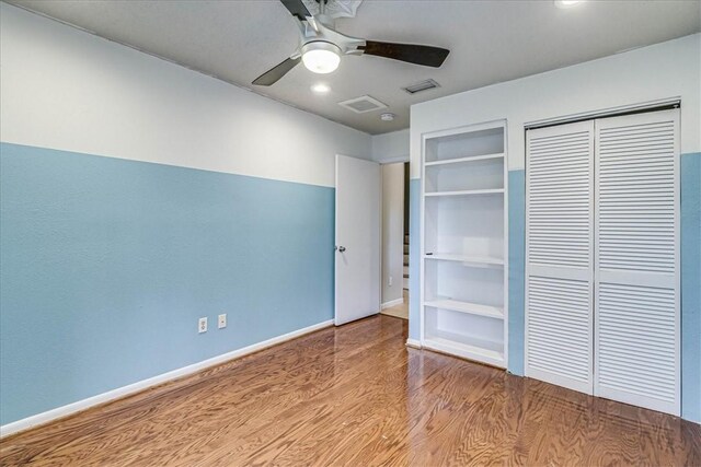 unfurnished bedroom with ceiling fan, a closet, and wood-type flooring