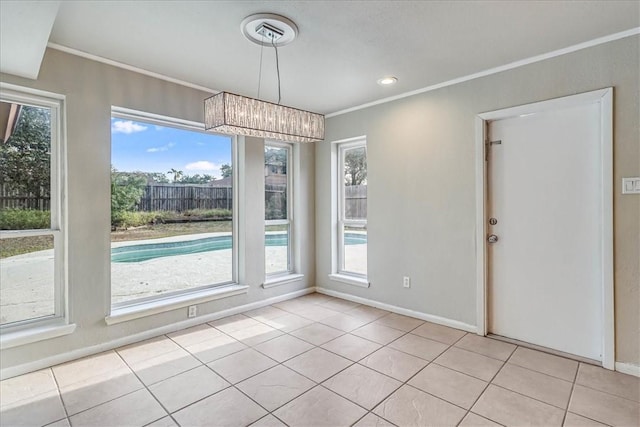 unfurnished dining area featuring crown molding, a wealth of natural light, light tile patterned flooring, and an inviting chandelier