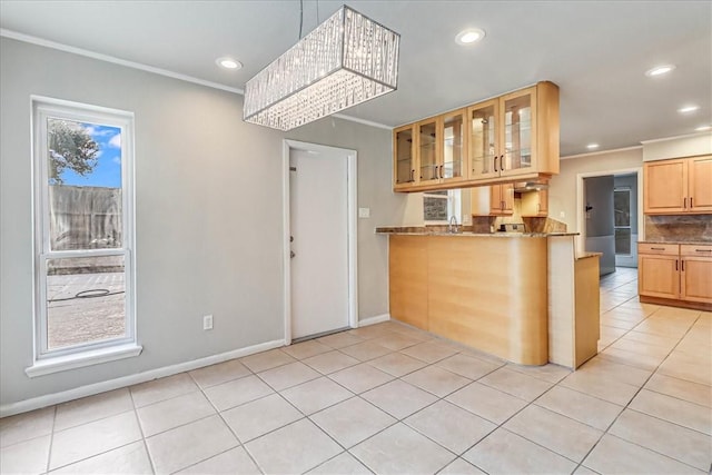 kitchen with tasteful backsplash, crown molding, light tile patterned floors, dark stone counters, and a chandelier