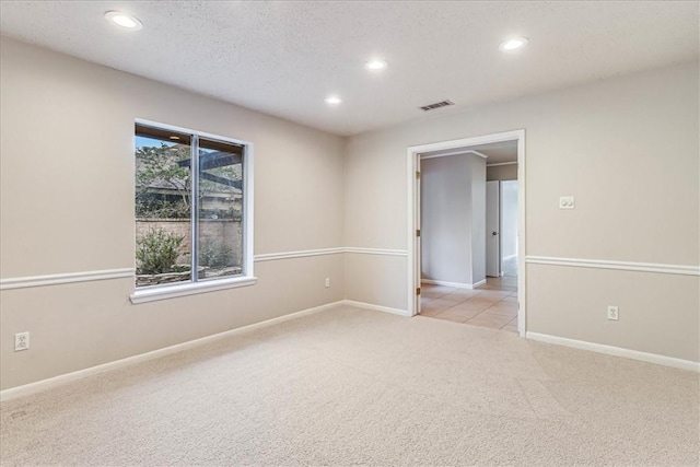 carpeted spare room featuring a textured ceiling