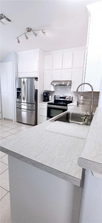 13829 Suntan Ave, Corpus Christi, TX 78418 - kitchen featuring stainless steel appliances, light tile patterned flooring, white cabinetry, under cabinet range hood, and light countertops