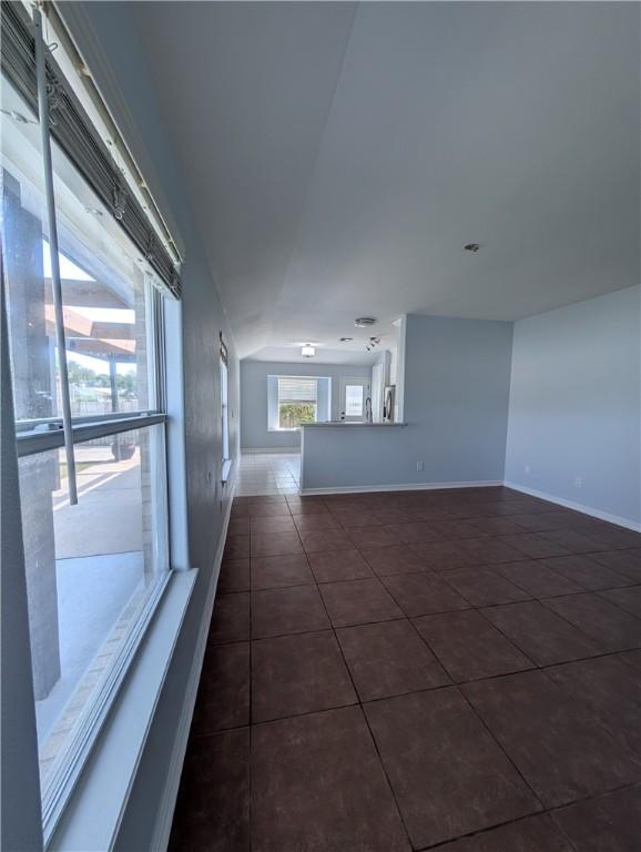 13829 Suntan Ave, Corpus Christi, TX 78418 - unfurnished room with dark tile patterned flooring and lofted ceiling