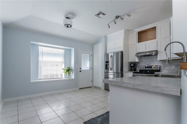 kitchen featuring backsplash, white cabinets, lofted ceiling, and appliances with stainless steel finishes