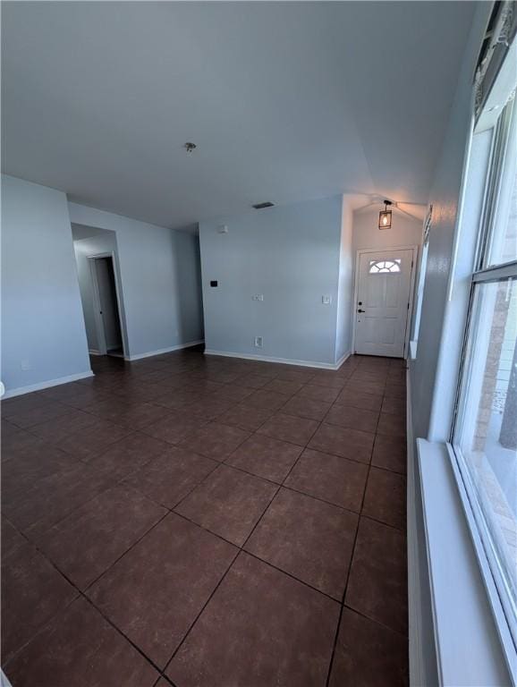 13829 Suntan Ave, Corpus Christi, TX 78418 - unfurnished living room with dark tile patterned floors and vaulted ceiling