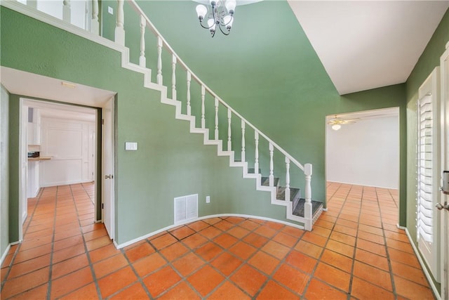 staircase with tile patterned flooring and a notable chandelier