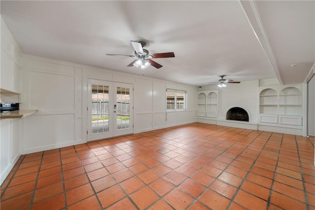 5049 Moultrie Dr, Corpus Christi, TX 78413 - unfurnished living room with ceiling fan, a decorative wall, built in features, a brick fireplace, and light tile patterned flooring