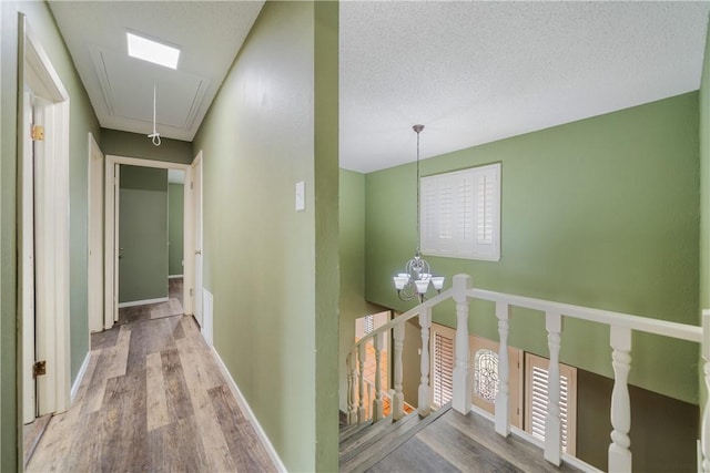 5049 Moultrie Dr, Corpus Christi, TX 78413 - hall with attic access, wood finished floors, an upstairs landing, and a chandelier