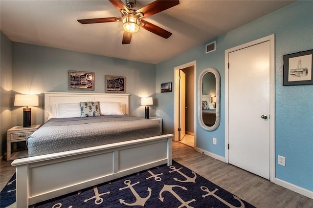 bedroom with dark wood-type flooring and ceiling fan