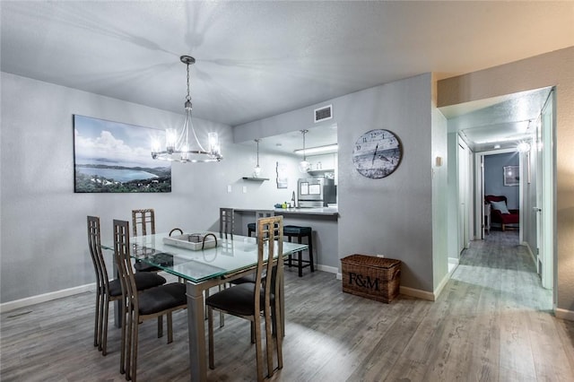 dining space with a chandelier and wood-type flooring