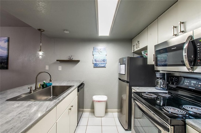 kitchen featuring pendant lighting, white cabinets, appliances with stainless steel finishes, light tile patterned flooring, and sink