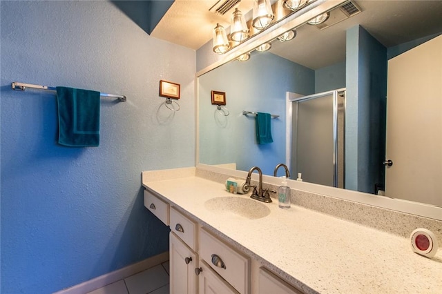 bathroom with tile patterned floors, walk in shower, and vanity