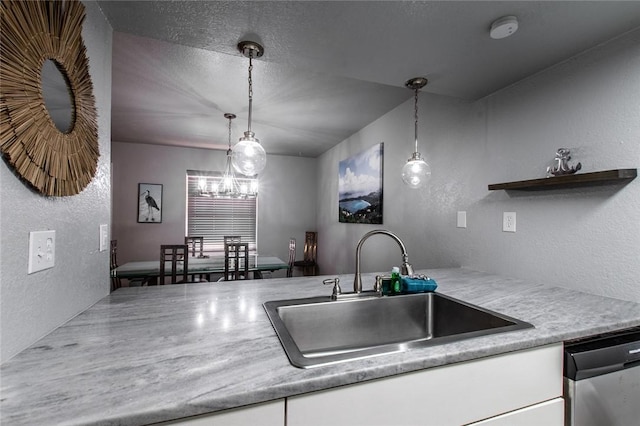 kitchen with decorative light fixtures, white cabinets, dishwasher, and sink