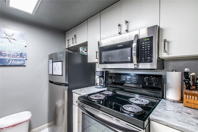 kitchen with appliances with stainless steel finishes and white cabinets