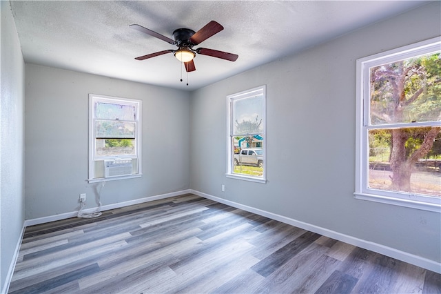 unfurnished room with hardwood / wood-style floors, ceiling fan, and a textured ceiling