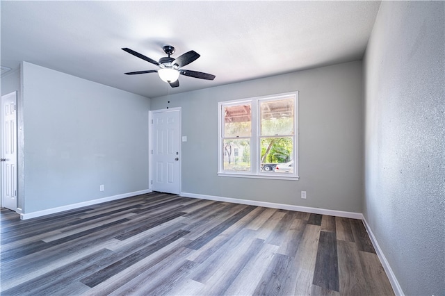 empty room with dark wood-type flooring and ceiling fan