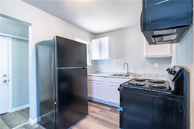 kitchen with light hardwood / wood-style floors, black appliances, sink, a textured ceiling, and white cabinetry