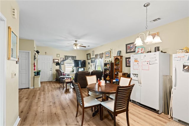 105 E Elm St, Taft, TX 78390 - dining space featuring light wood-style flooring, a chandelier, and a ceiling fan