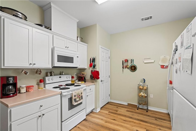 105 E Elm St, Taft, TX 78390 - kitchen featuring white appliances, light wood-style floors, white cabinets, and light countertops