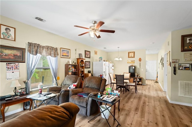 105 E Elm St, Taft, TX 78390 - living area featuring ceiling fan, light wood-style flooring, and a chandelier